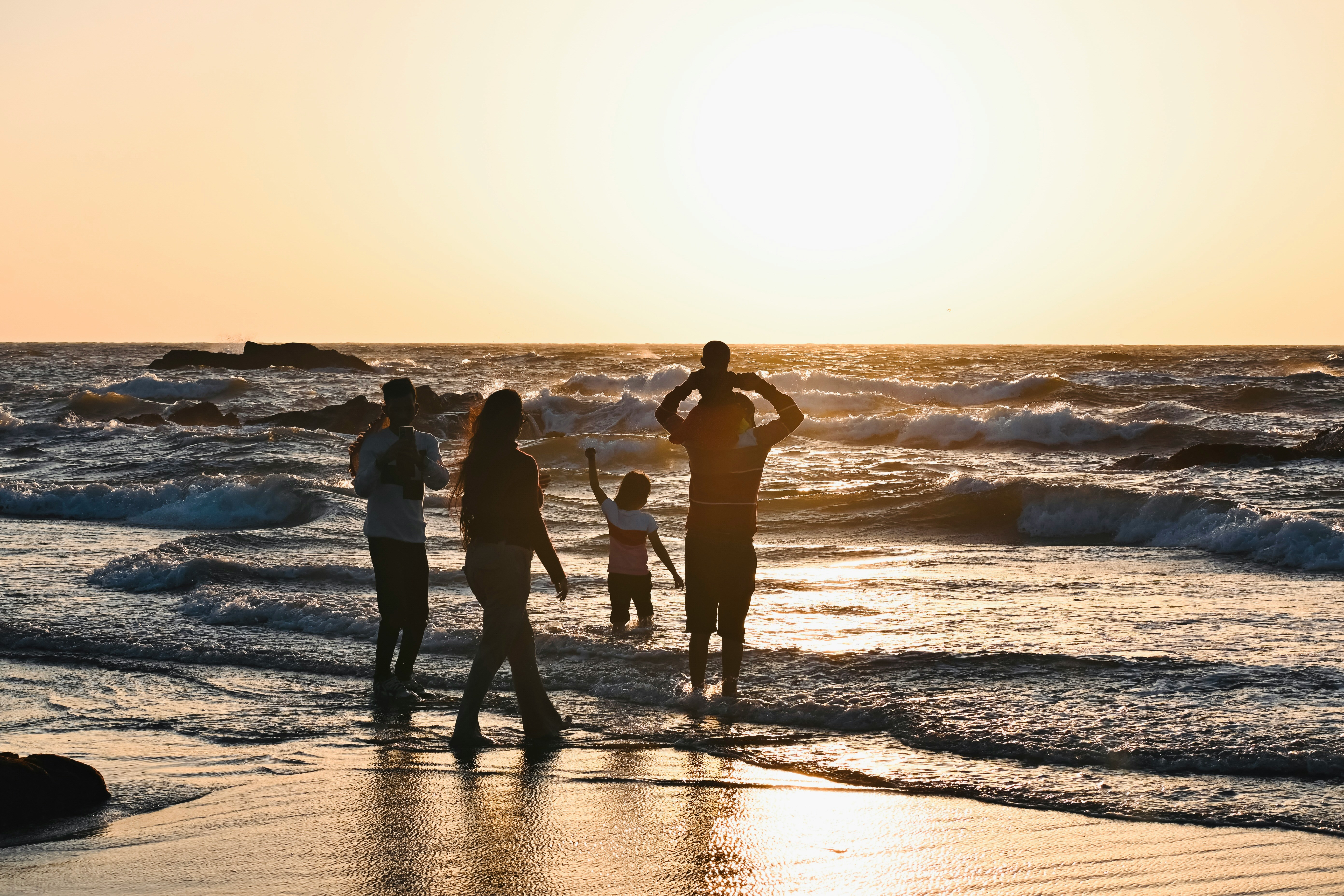 family walkiong on the beach at sunset in destin florida