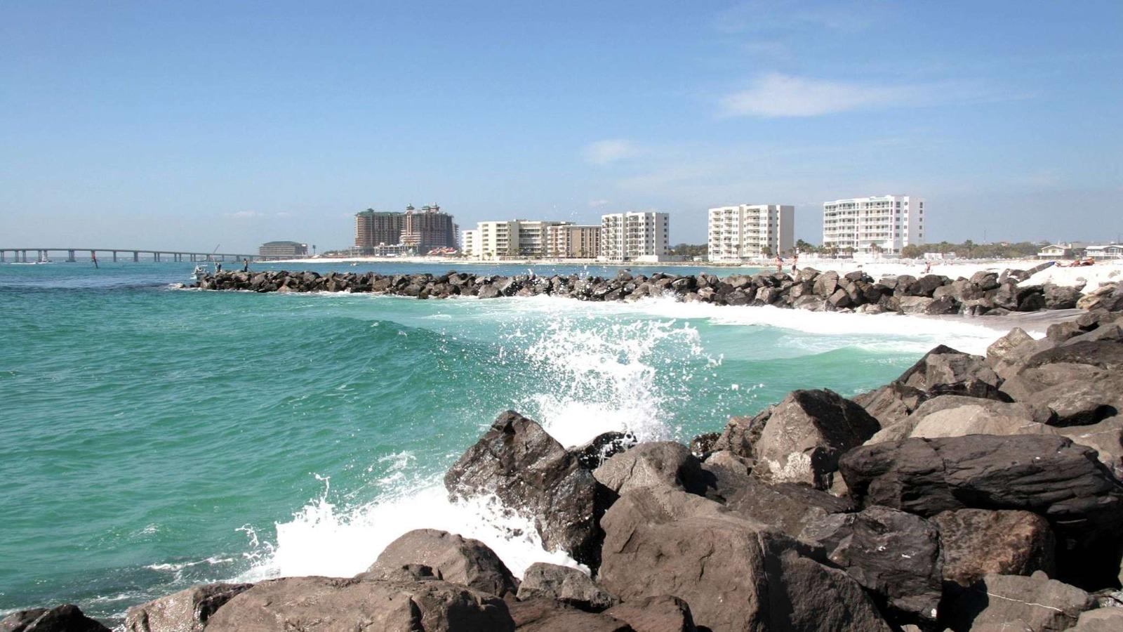 Destin Jetties with buildings in the background along the coastline